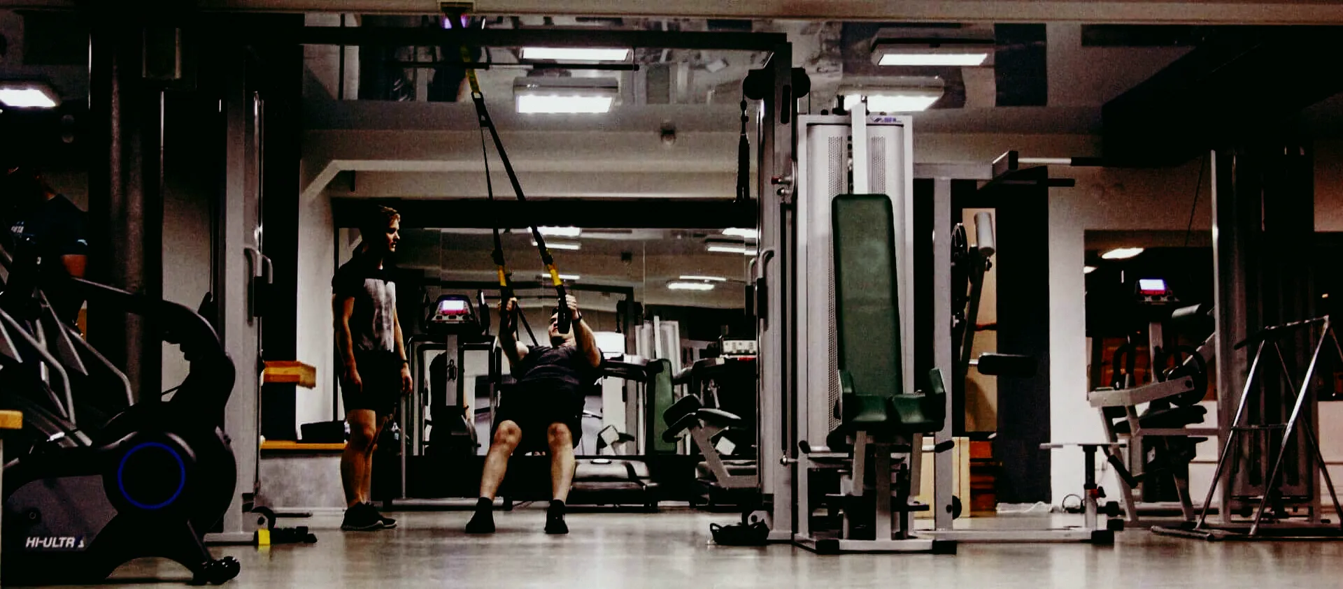 Тренер FitMe поруч із клієнтом на TRX-петлях
